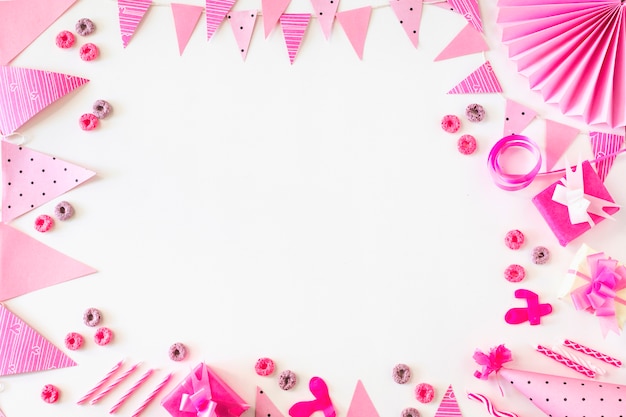 Birthday gifts and froot loops candies with party accessories on white backdrop