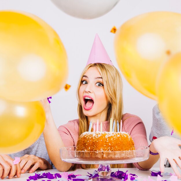 Birthday girl and friends behind balloons