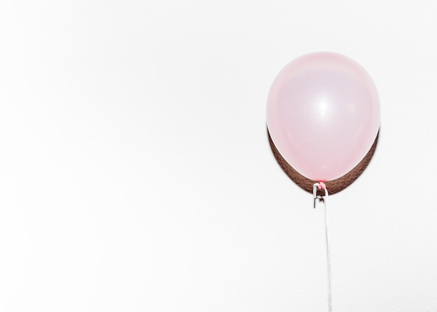 Free photo birthday pink balloon with shadow against white background