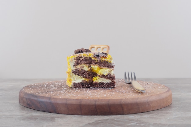 Free Photo biscuit and anise on a cake slice next to a fork on a board on marble 