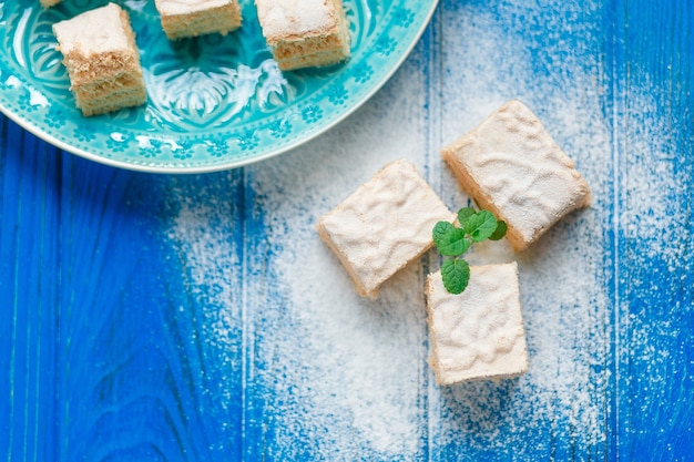 Free photo biscuit cake pie apple candy pastila decorated with mint leaves on blue wood cutting board