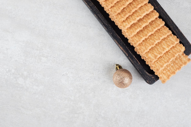 Biscuits and Christmas ball on marble surface