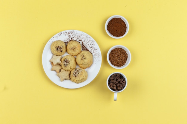 Biscuits and coffee beans on a yellow background