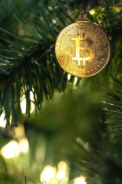 Bitcoin coin on christmas tree with bokeh lights finance concept