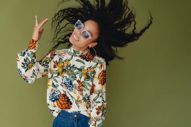 black african american woman in stylish outfit jeans and blouse isolated on green