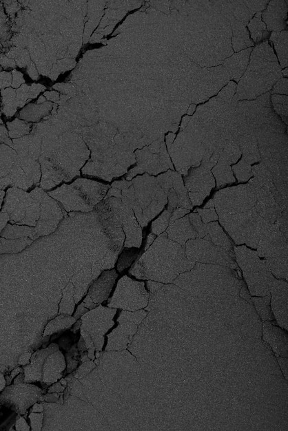 Free photo black background with cracked sand