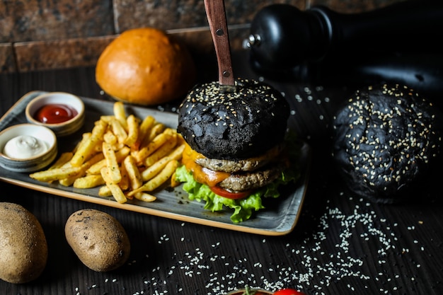 Free photo black beef burger with ingredients and french fries