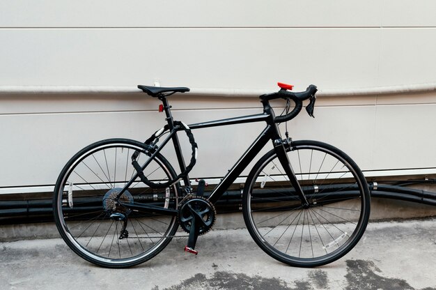 Black bicycle tied outdoors