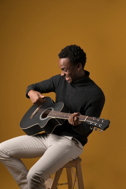 Free Photo black boy playing the guitar