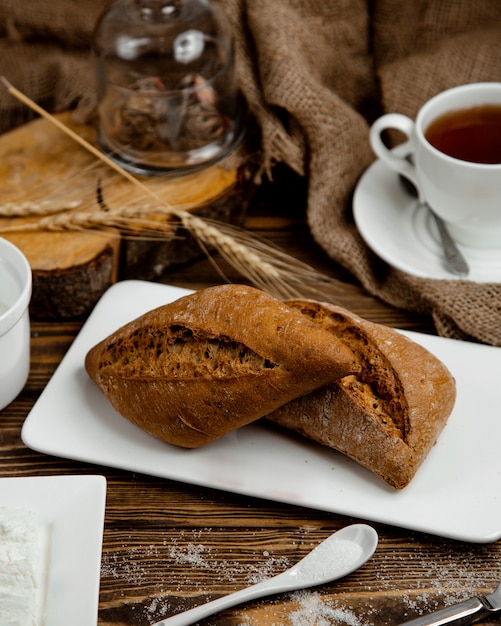 Black bread made of wheat on a white plate