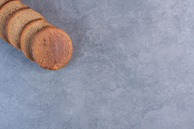 Black bread slices lined up on marble background. High quality photo