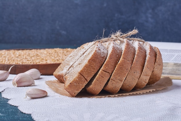 Black bread with garlic on blue table.