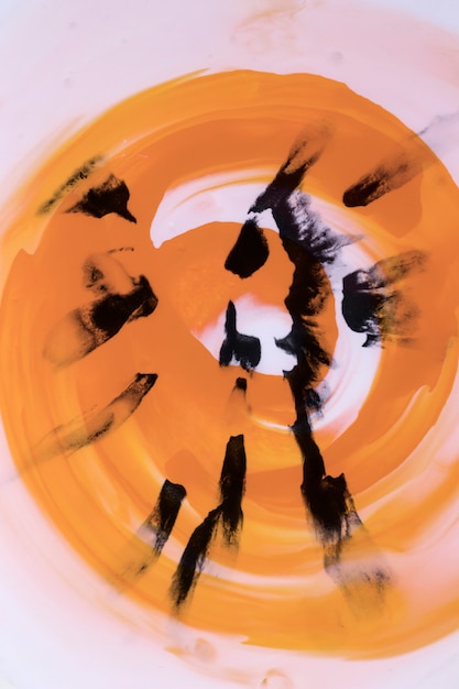 Free photo black brushstroke on swirl orange watercolor