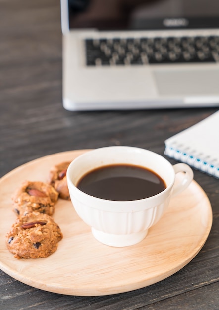 black coffee and cookies with laptop and note book