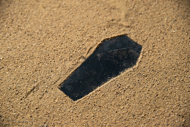 Free photo black coffin shape made on the sand