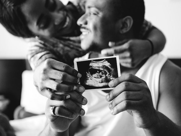 Free Photo black couple showing baby ultrasound scan photo