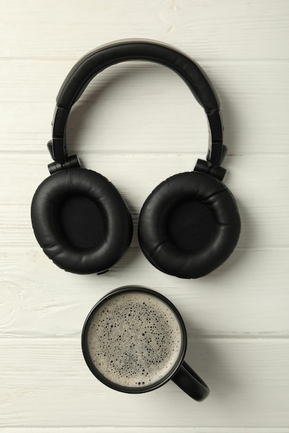 Free Photo black cup with black headphones on a light background