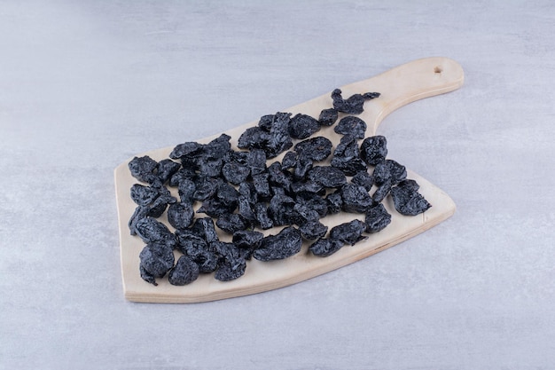 Free photo black dried sultanas isolated on concrete background. high quality photo