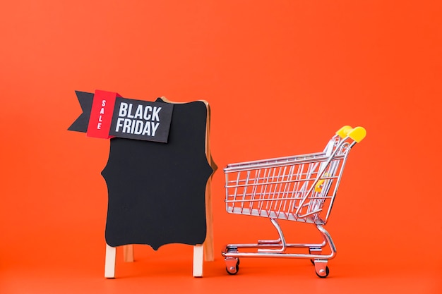 Free photo black friday decoration with small cart next to board