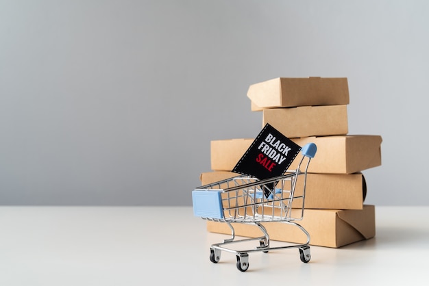 Free Photo black friday shopping cart in front of boxes