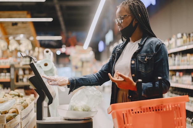 Black girl in a mask buy a food