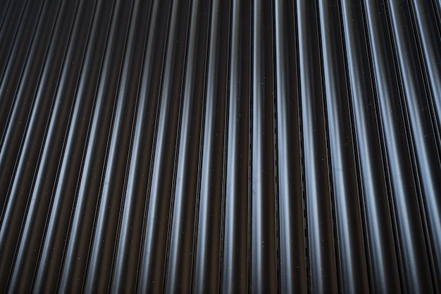 Black iron tin fence lined background. Metal texture