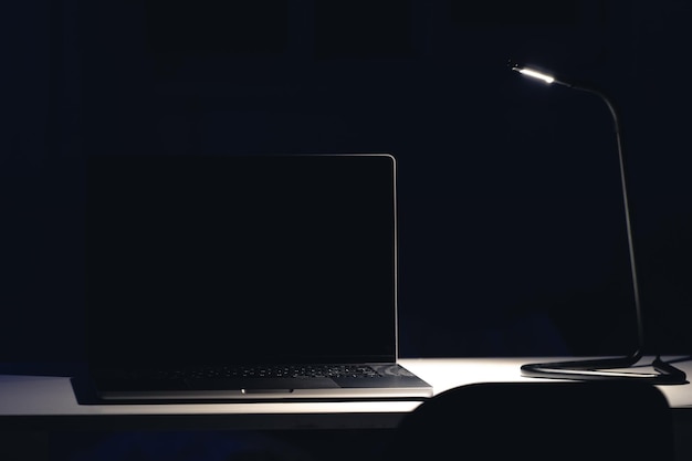 Free photo black laptop screen in a dark room at night