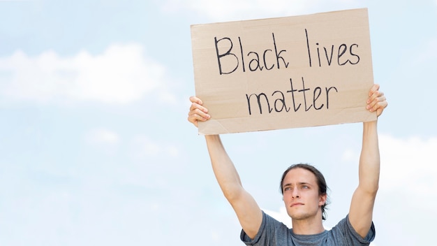 Free photo black lives matter concept person holding cardboard