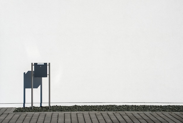 Free photo black mailbox in front of a white concrete wall