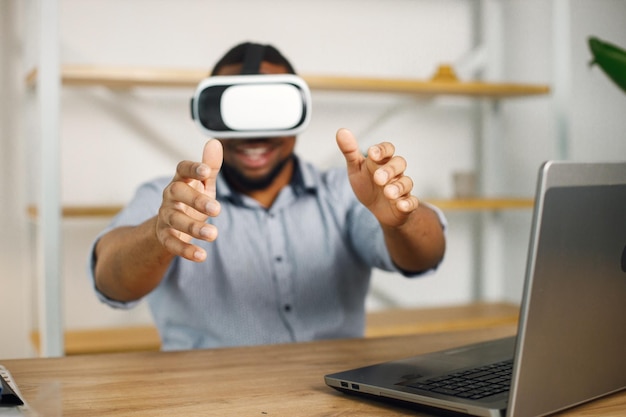 Free Photo black male entrepreneur sitting in office and using virtual reality glasses