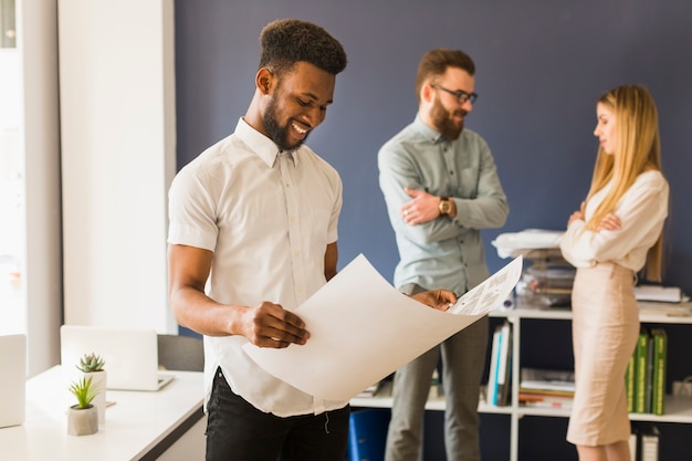 Free photo black man looking at draft in office