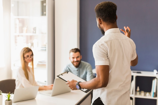 Free photo black man presenting strategy to coworkers