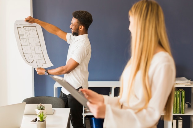 Free Photo black man showing blueprint to woman