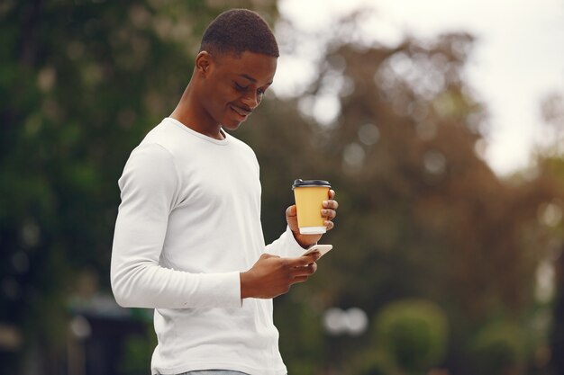 Black man in a white sweater in a summer city