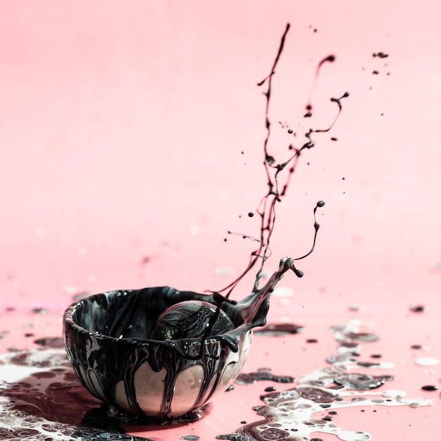 Free photo black paint splash and cup abstract background