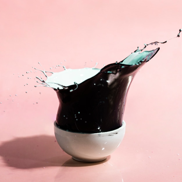 Free photo black paint splash and cup abstract background