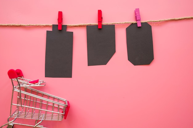 Free Photo black paper tallies hanging on thread near shopping trolley 