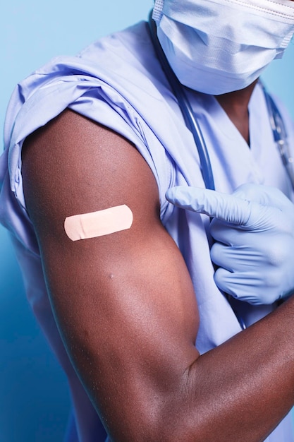 Free Photo black person pointing to vaccine plaster