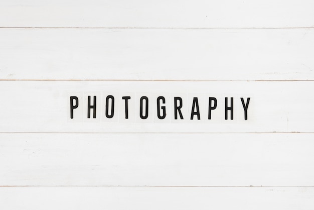 Free photo black photography text on white wooden table