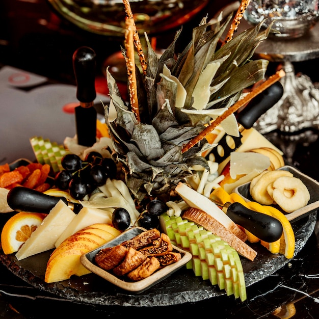 Free Photo black plate of fruits and dried fruits