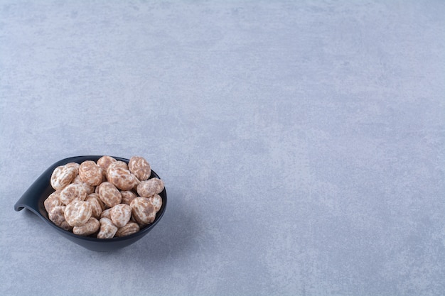 A black plate full of healthy cereals on gray table. 