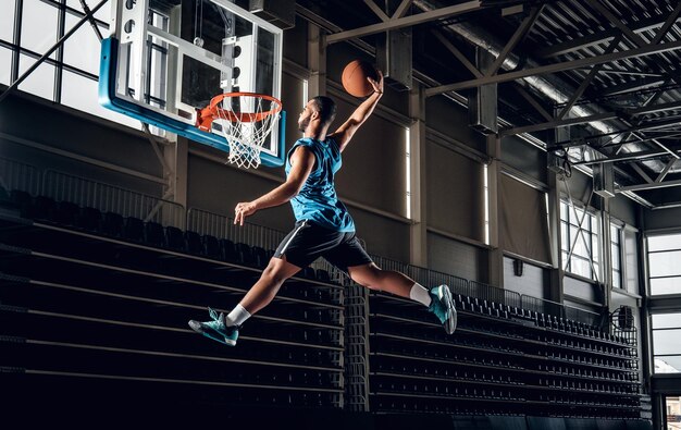 Black professional Black basketball player in action in a basketball court.