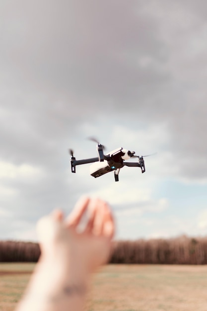 Free photo black quadcopter drone over a cloudy sky