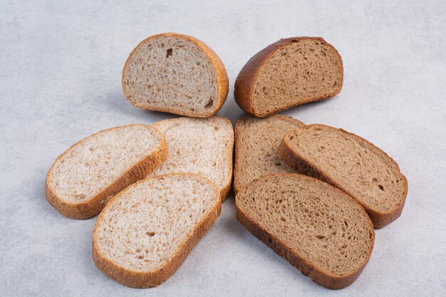 Black and rye bread slices on stone surface