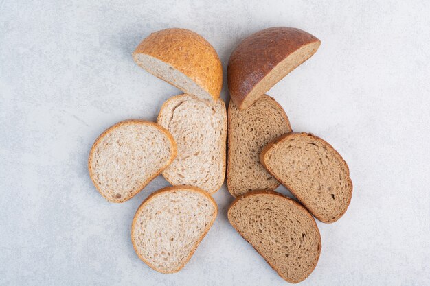 Black and rye bread slices on stone surface