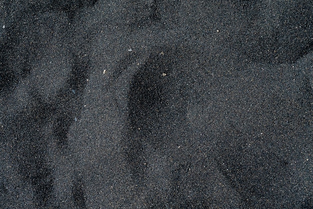 Black sand beach with pebble. Tenerife volcanic sandy shore.