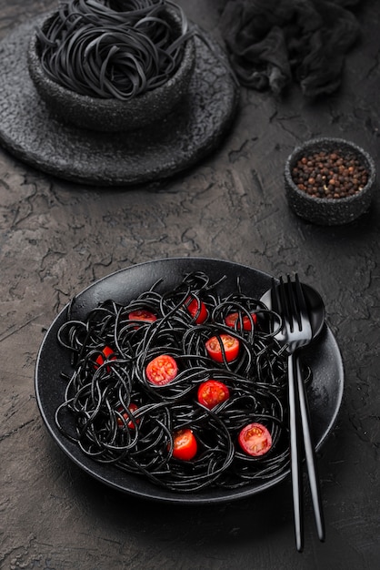 Black spaghetti on plate with tomatoes