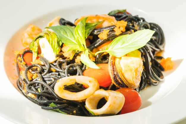 Black Spaghetti with seafood in white plate