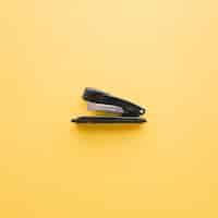 Free photo black stapler on orange background