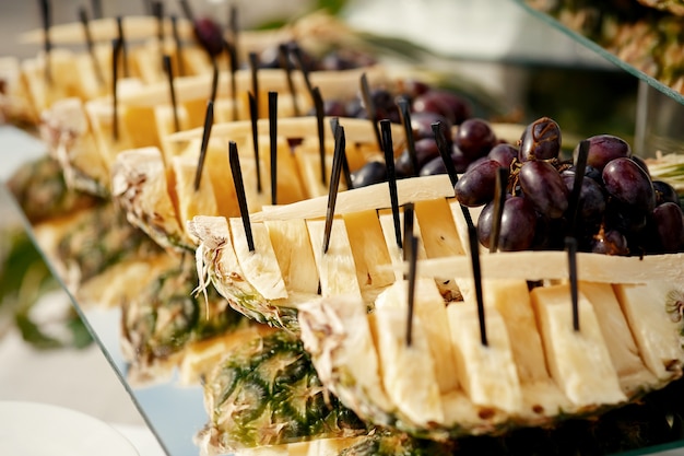 Free Photo black stick put in pieces of ananas on long glass plate 